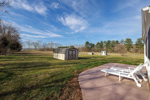 view of yard featuring an outbuilding, a shed, and a patio area
