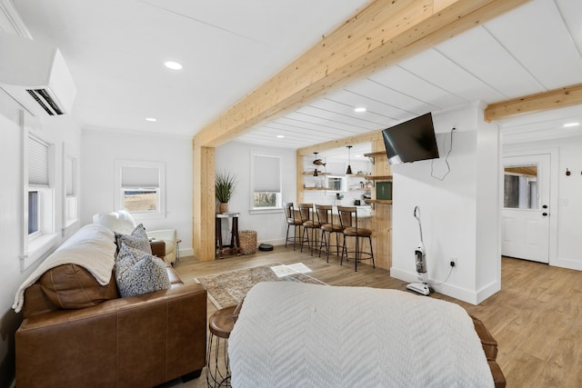 living room with beam ceiling, an AC wall unit, wood finished floors, recessed lighting, and baseboards
