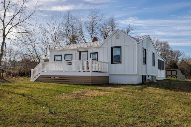 view of front facade featuring an outbuilding, board and batten siding, a storage shed, and a front yard