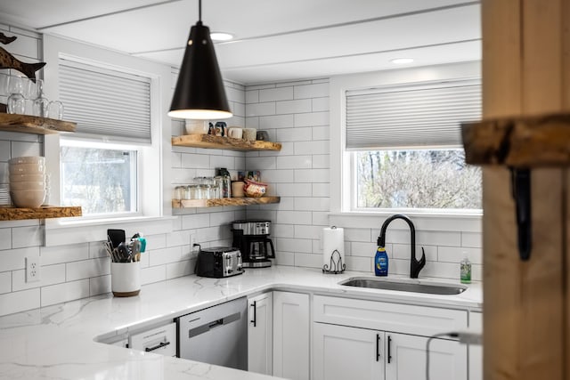 kitchen featuring a sink, backsplash, light stone countertops, dishwasher, and open shelves