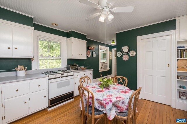 kitchen featuring white cabinetry, ornamental molding, light hardwood / wood-style flooring, and gas range gas stove