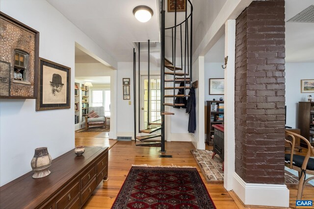 entryway featuring light hardwood / wood-style floors and brick wall