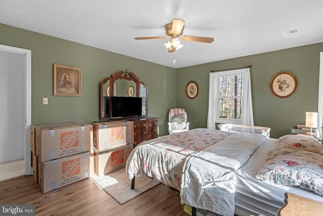 bedroom with visible vents, ceiling fan, and wood finished floors