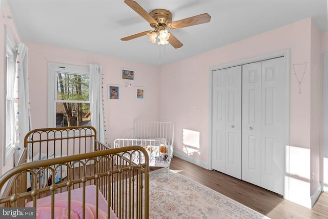 bedroom featuring baseboards, a closet, a ceiling fan, and wood finished floors