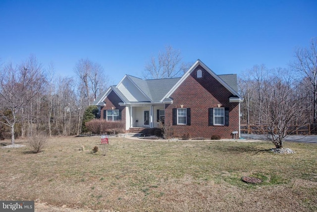 view of front facade with brick siding and a front lawn