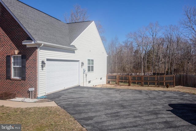 view of home's exterior with aphalt driveway, crawl space, an attached garage, and fence