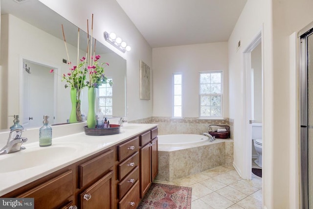 bathroom with toilet, a sink, tile patterned flooring, double vanity, and a bath