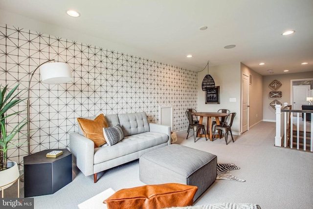 living room with carpet floors, an accent wall, baseboards, and recessed lighting