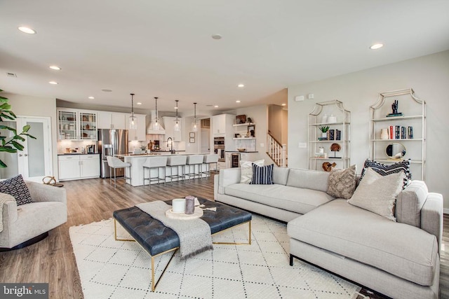 living area with stairway, recessed lighting, and light wood-style floors