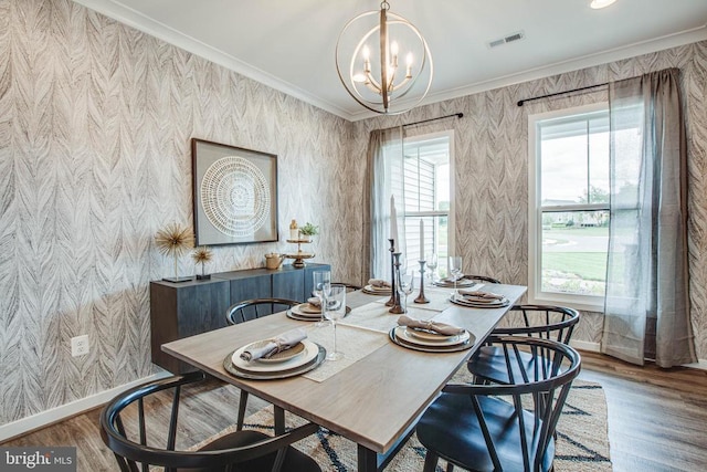 dining room featuring crown molding, visible vents, wood finished floors, baseboards, and wallpapered walls