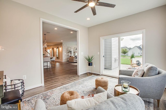 living room featuring ceiling fan, baseboards, wood finished floors, and recessed lighting