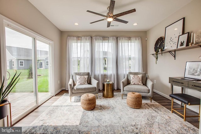 living area with a ceiling fan, recessed lighting, baseboards, and wood finished floors