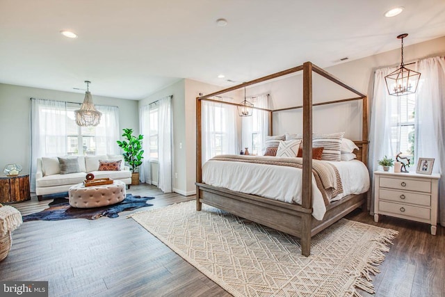 bedroom featuring recessed lighting, a notable chandelier, wood finished floors, visible vents, and baseboards