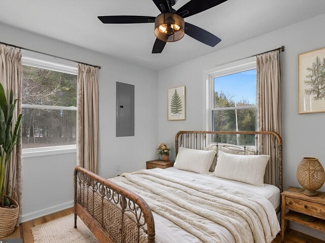 bedroom featuring ceiling fan, wood-type flooring, and electric panel