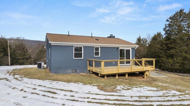 snow covered back of property with a wooden deck and central air condition unit