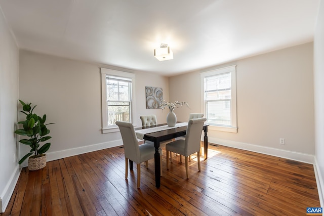 dining room featuring a healthy amount of sunlight, baseboards, and wood-type flooring