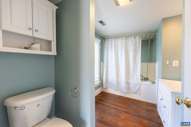 full bathroom with visible vents, toilet, wood-type flooring,  shower combination, and vanity