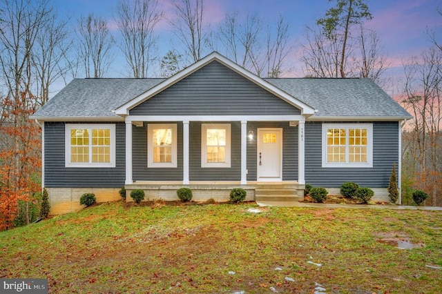 single story home featuring covered porch and a lawn