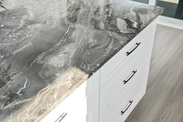 details featuring white cabinetry and dark stone counters