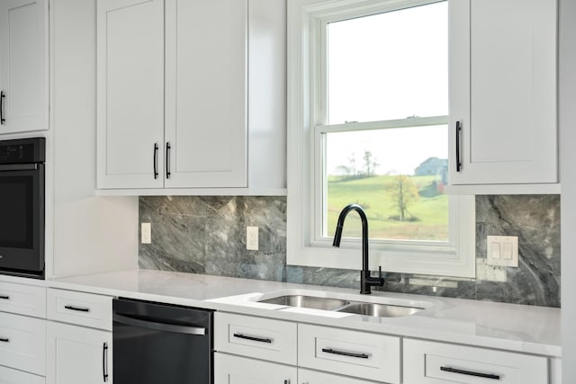 kitchen with sink, black appliances, white cabinets, light stone countertops, and backsplash