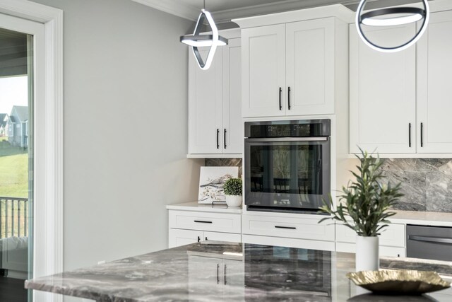 interior space with white cabinetry, pendant lighting, oven, and decorative backsplash