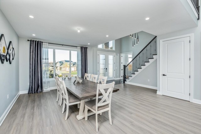 dining space featuring light wood-type flooring and french doors