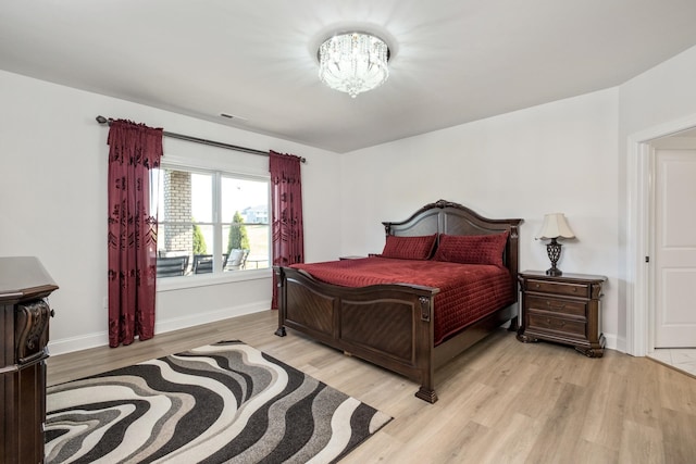 bedroom featuring a notable chandelier and light wood-type flooring