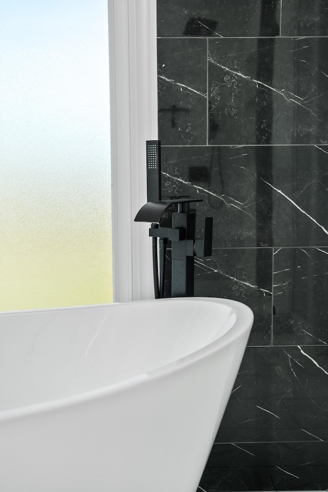 bathroom featuring tile walls and a bathtub