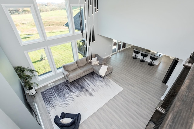 living room with a towering ceiling and wood-type flooring