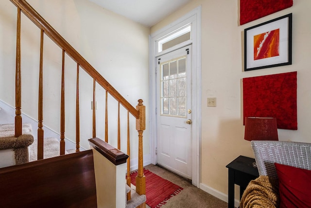 entryway featuring stairs, baseboards, and carpet flooring