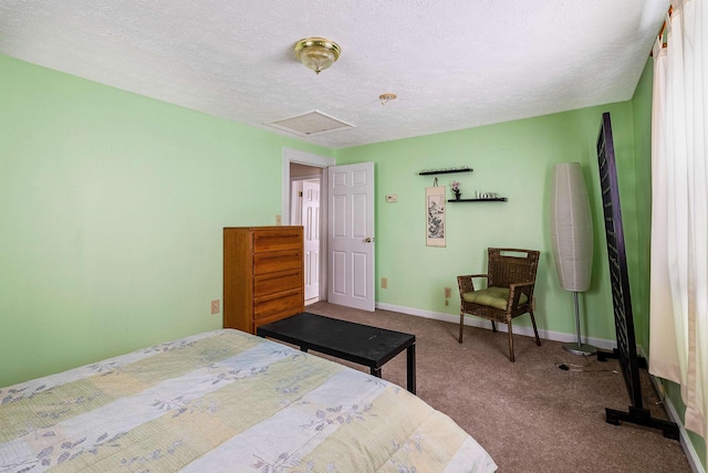 carpeted bedroom featuring a textured ceiling, attic access, and baseboards