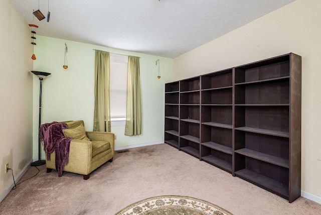 sitting room with carpet floors, visible vents, and baseboards