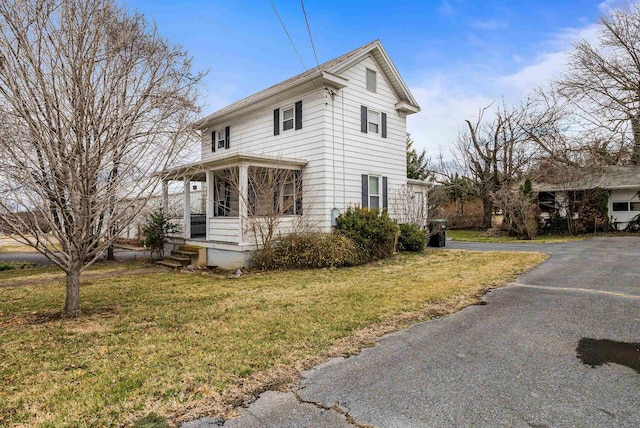 view of front of house featuring covered porch and a front lawn