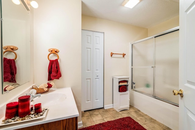 bathroom with tile patterned flooring, a closet, enclosed tub / shower combo, and vanity