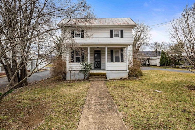 view of front of property featuring covered porch, metal roof, and a front lawn