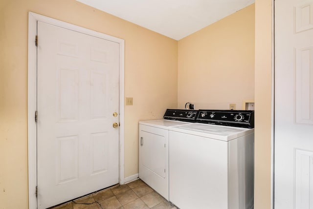 clothes washing area with washer and dryer, laundry area, and baseboards