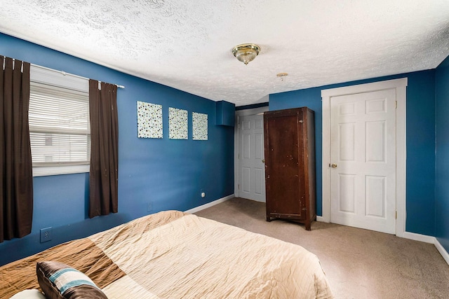 unfurnished bedroom with a textured ceiling, carpet, and baseboards