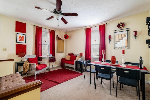 carpeted dining area with ceiling fan, a textured ceiling, and a wealth of natural light