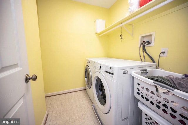 clothes washing area with light floors, baseboards, washer and clothes dryer, and laundry area