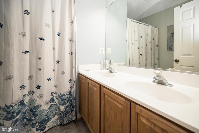 full bath featuring curtained shower, double vanity, tile patterned flooring, and a sink