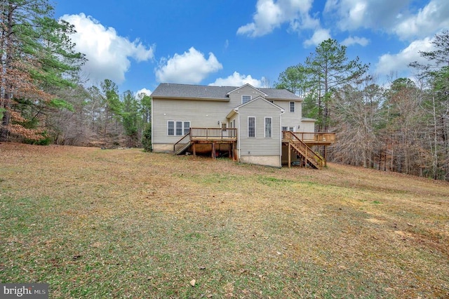 back of property with a lawn, a wooden deck, and stairs
