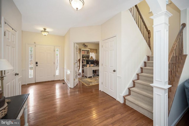 entryway with stairway, baseboards, hardwood / wood-style floors, and decorative columns