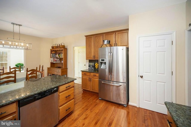 kitchen featuring brown cabinets, light wood-style floors, pendant lighting, and stainless steel appliances