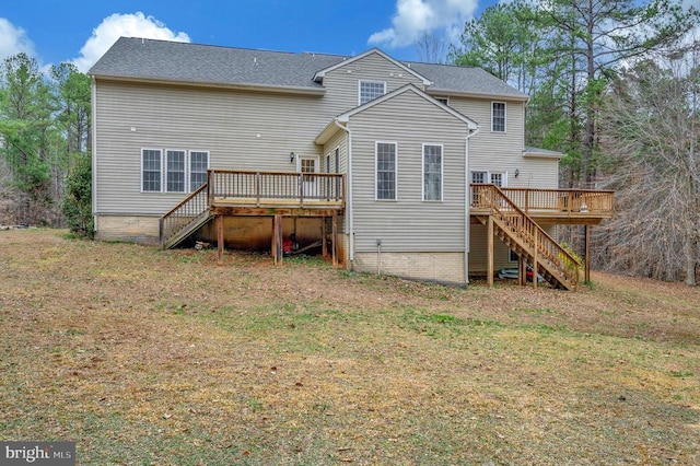 back of property with a yard, stairs, and a deck