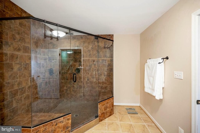 bathroom featuring a shower stall, baseboards, and tile patterned floors