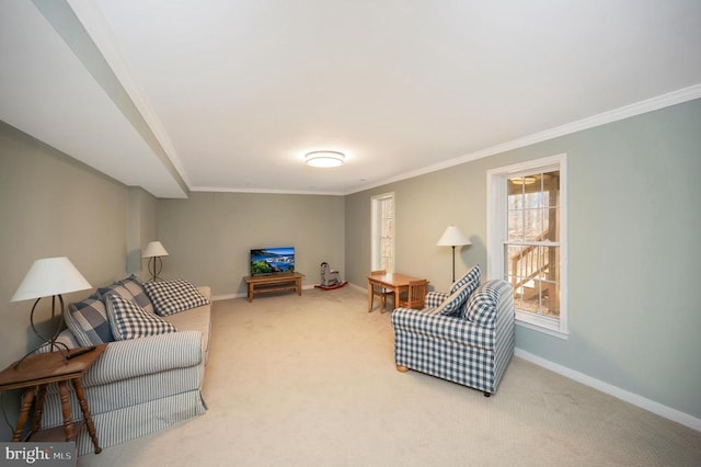 living area with carpet floors, crown molding, and baseboards