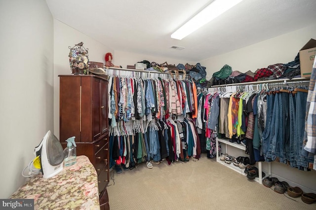 walk in closet featuring visible vents and carpet flooring