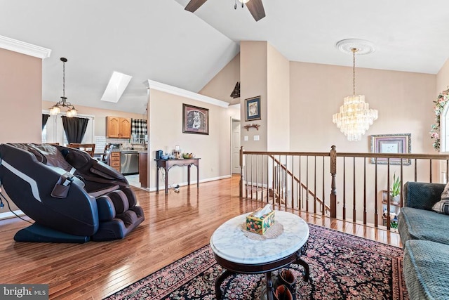 living room featuring lofted ceiling with skylight, ceiling fan with notable chandelier, and light wood-type flooring