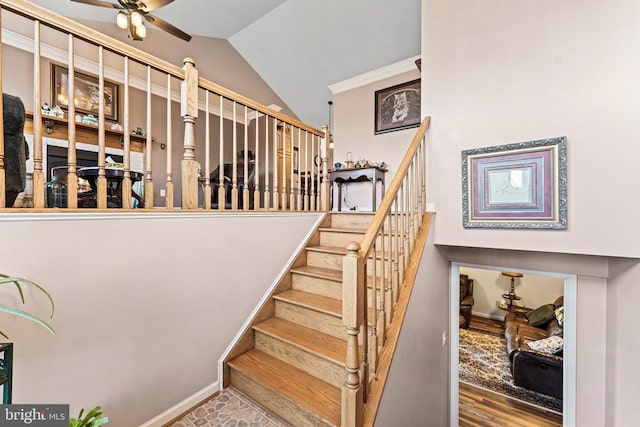 stairway with ceiling fan, lofted ceiling, and hardwood / wood-style floors