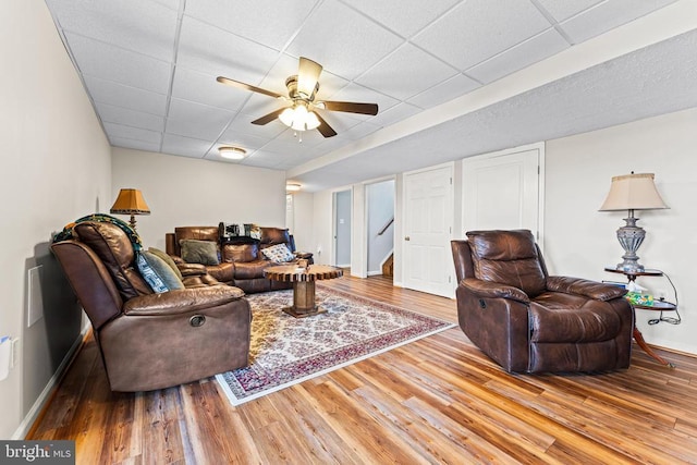 living room with ceiling fan, hardwood / wood-style floors, and a drop ceiling